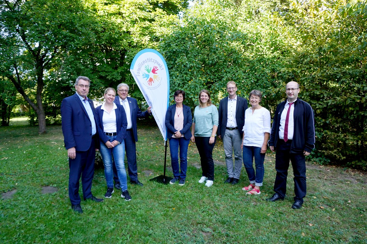 Gruppenbild mit Flagge mit Logo Familienstützpunkte