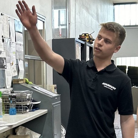 Paul Azubi im Autohaus Meyer zeigt auf die Aufträge 