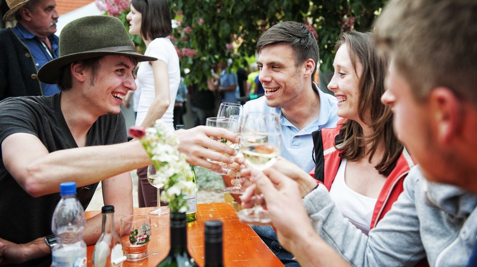 ©Florian Trykowski Weinfestbesucher stoßen mit Wein an.
