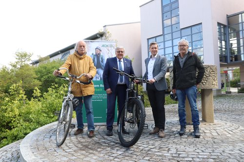 Vier Personen bei der Auftaktveranstaltung zu "Mit dem rad zur Arbeit" vor dem Landratsamt in Neustadt a.d.Aisch