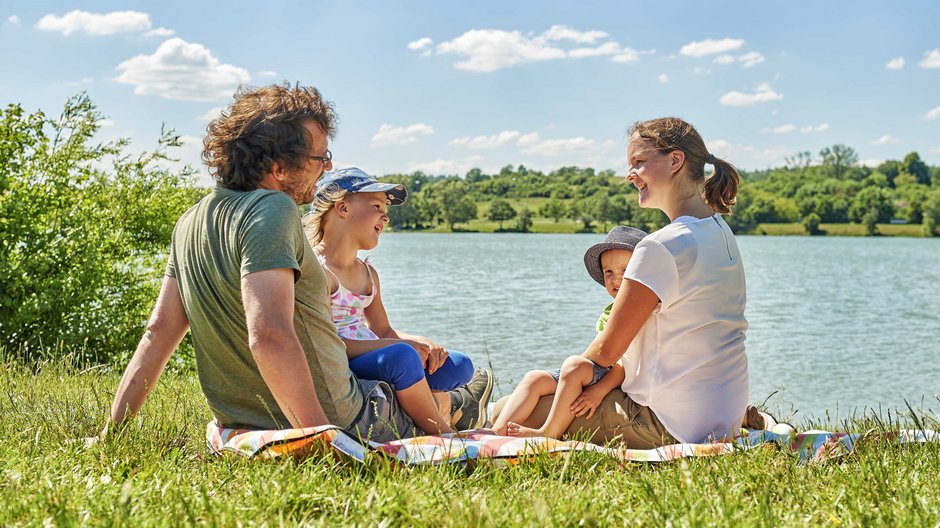 ©Florian Trykowski Eine Familie mit zwei kleinen Kindern sitzt am Obernzenner See.